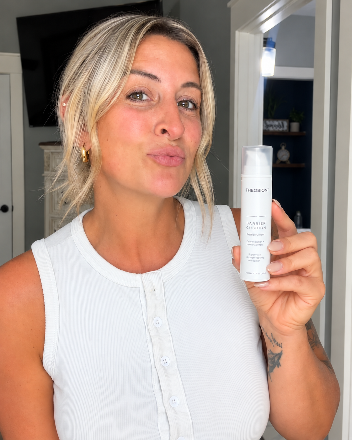 Skincare creator holding Theobion Barrier Cushion Peptide Cream